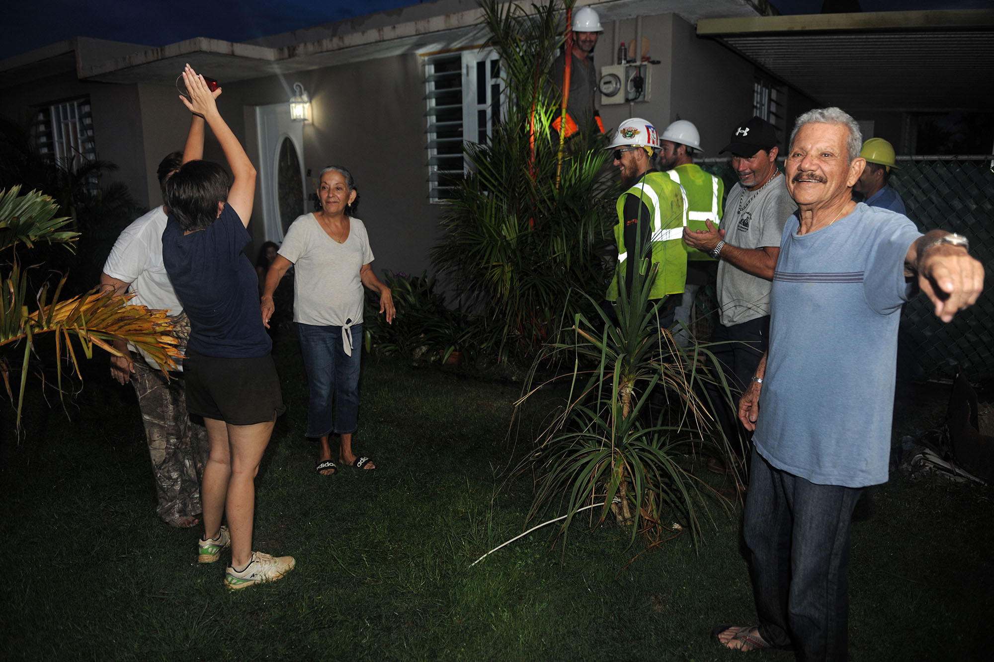 People outside of a house at nighttime looking happy